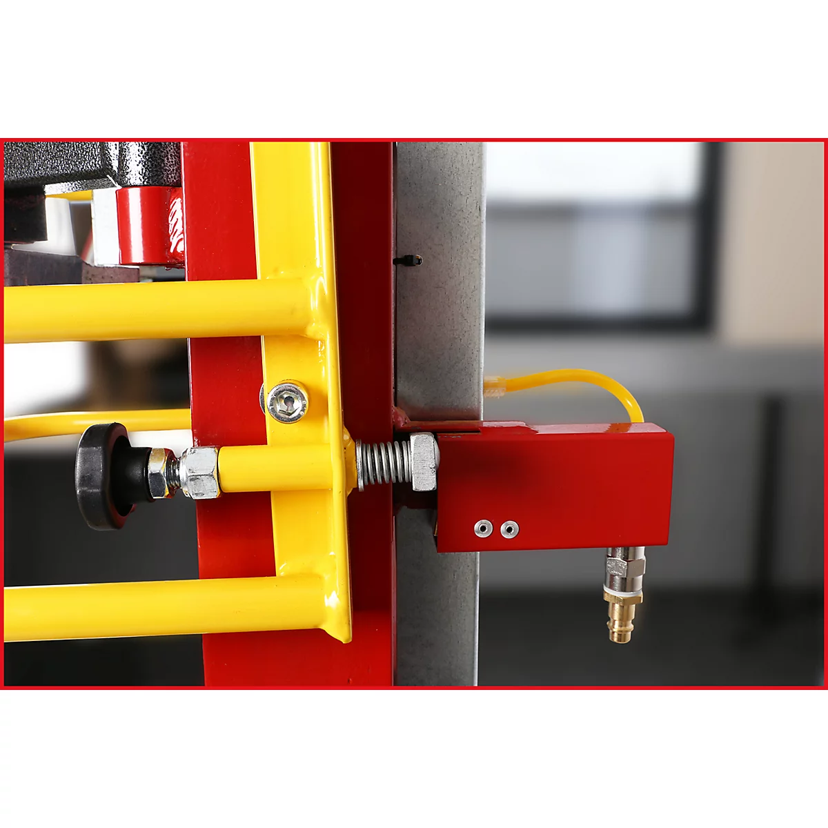 Detailansicht eines roten und gelben Maschinenteils. Gelbe Rohre, rote Blöcke, gelbe Schlauch- und Schraubverbindungen.